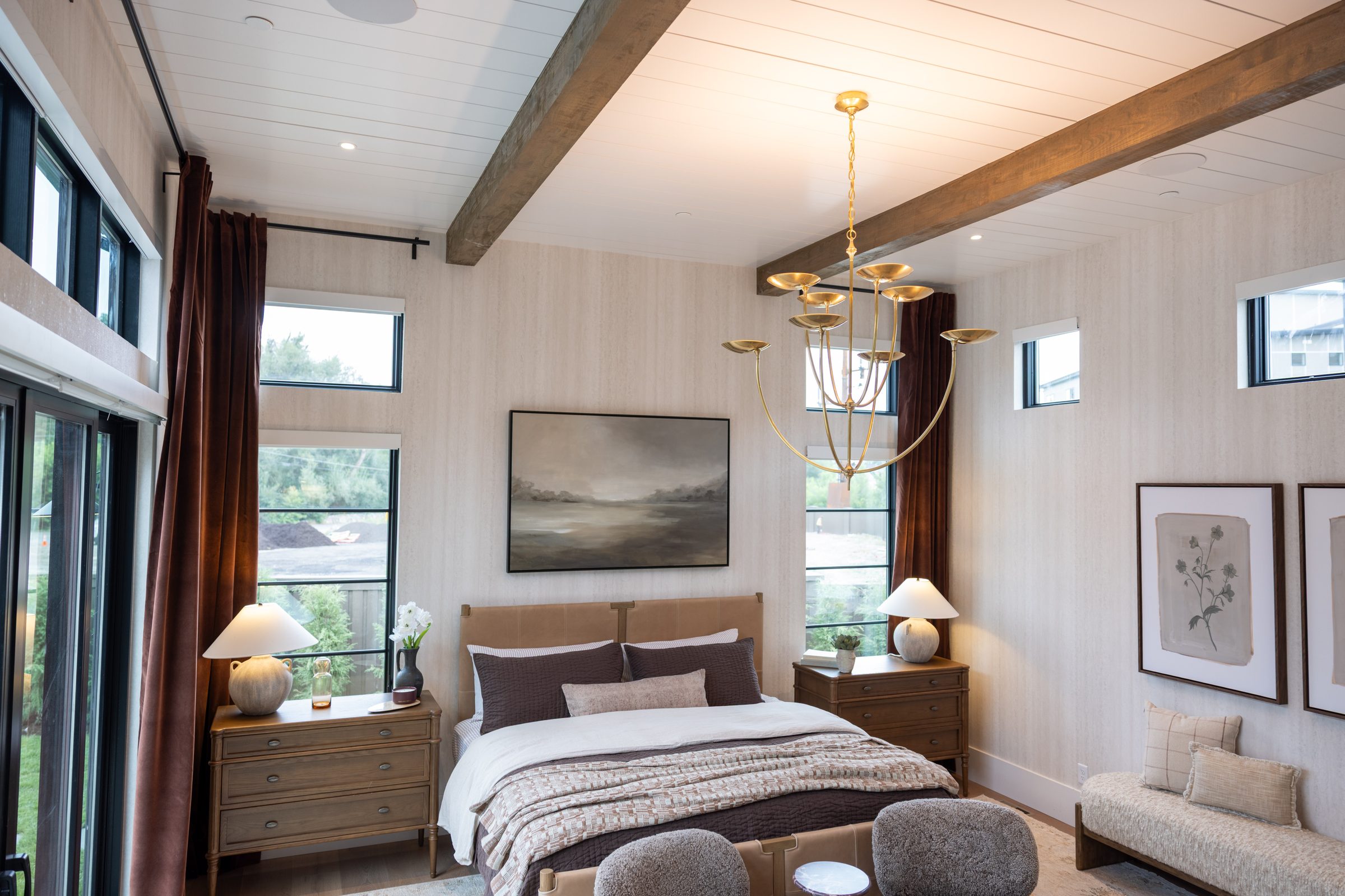 A warm, professionally lit bedroom with a wood beam ceiling wired by Ram Electric